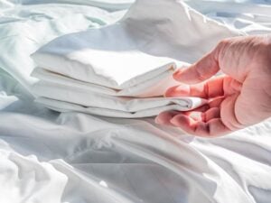 Mão segurando lençóis brancos