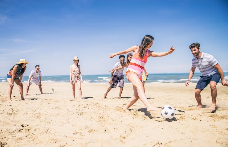 Jovens jogando futebol na praia